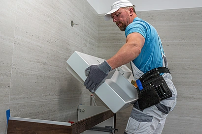 Illustration - Ihr Experte für schönes Wohnen - Handwerker installiert einen Waschtisch im Badezimmer.