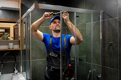Illustration - Ihr Experte für schönes Wohnen - Handwerker montiert eine Duschabtrennung im Badezimmer.
